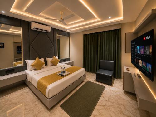 a hotel room with a bed and a flat screen tv at Hotel The Sun B&B in New Delhi