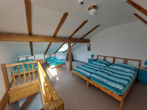 a bedroom with two beds in a room with wooden ceilings at Penzion Manský Dvůr in Dolní Žandov