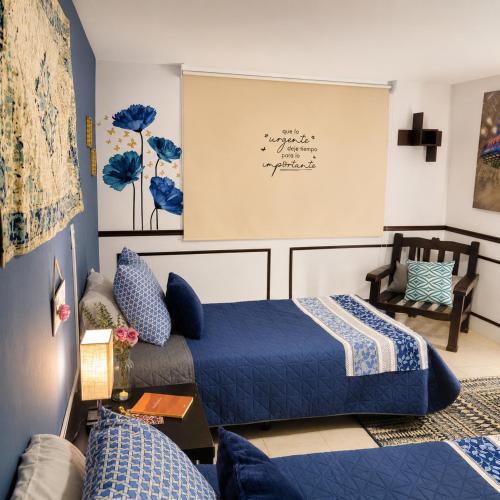 ein Schlafzimmer mit einem blauen Bett und einem Sofa in der Unterkunft Casa Aoi Ideal para empresas y grupos de trabajo in Pachuca de Soto