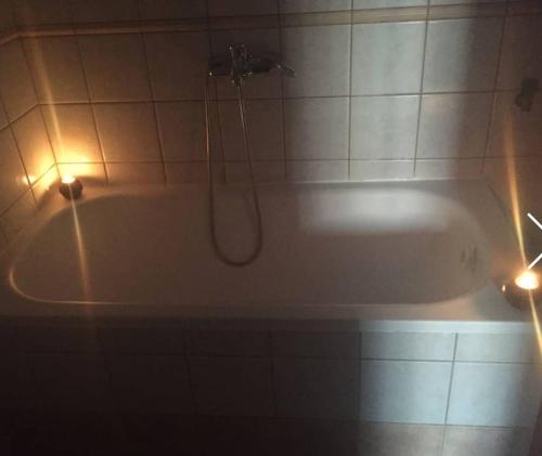 a bathroom with a tub with a shower and lights at Filoxenia Apartments in Skala Sotiros