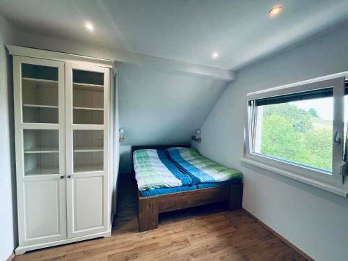 a small room with a bed and a window at M&M house in Bizeljsko