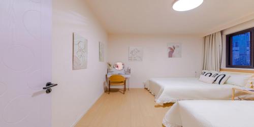 a white room with two beds and a window at Uffice apartment in Shanghai