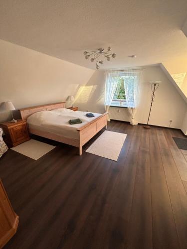 a bedroom with a bed and a wooden floor at Margarethe in Süderlügum
