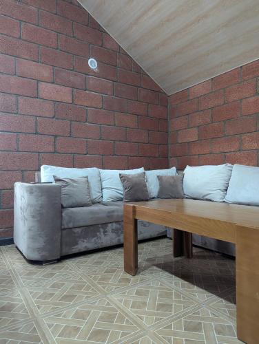 a couch in a room with a brick wall at Sevan Grass and Sky in Sevan