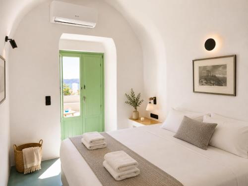 a white bedroom with a bed with towels on it at Mamma Mia Santorini Suites-Volcano -Caldera -Sunset View in Fira