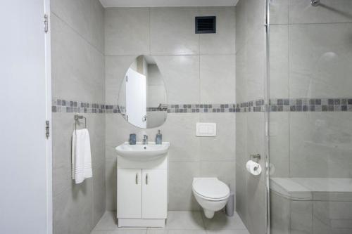 a bathroom with a toilet and a sink and a shower at Hibernian Towers 408 in Strand