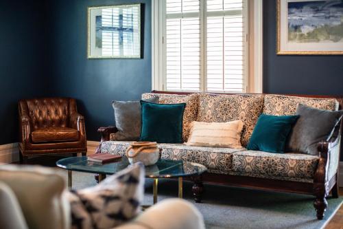 a living room with a couch and a table at The Edenton Collection – Captain’s Quarters Inn in Edenton
