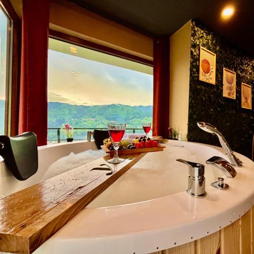 a bathroom with a sink and a window with a view at YAYLAMİSUN SUITE HOTEL Luxury Nature Stay Çamlıhemşin in Çamlıhemşin