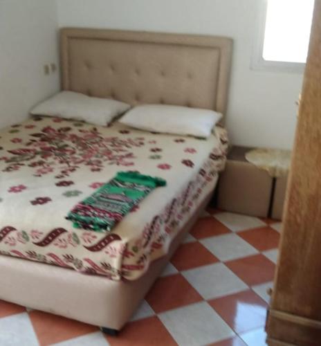 a bedroom with a bed with a checkered floor at Resicence jaouharat zarkaa in M'diq