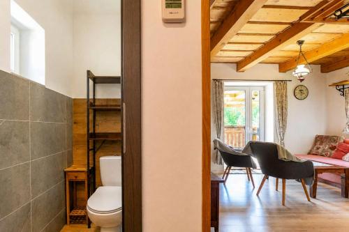 a room with a toilet and a table and chairs at Norova chata in Závažná Poruba