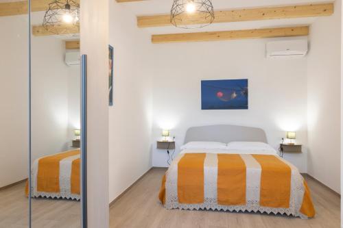 ein Schlafzimmer mit einem Bett, zwei Lampen und einem Spiegel in der Unterkunft Pasithea House in Lanciano