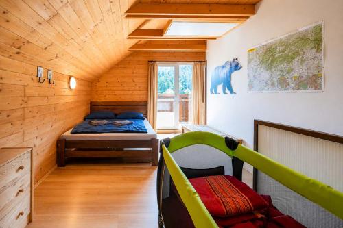 a bedroom with a bed in a wooden house at Norova chata in Závažná Poruba