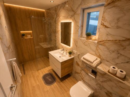 a bathroom with a toilet and a sink and a shower at AMD Apartamenty Ustka *** in Ustka