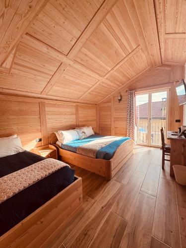 a bedroom with two beds and a wooden ceiling at La Gemma Bed & Breakfast in Montesover