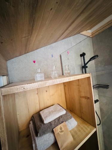 a small bathroom with a shelf with glasses and towels at La Gemma Bed & Breakfast in Montesover