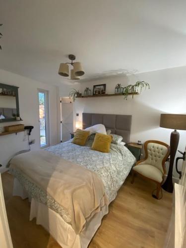 a bedroom with a bed and a chair at The Rest-Well Lodge in Sherborne