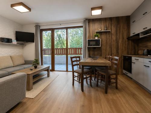 a kitchen and living room with a table and chairs at Ski & Sun Wellness Apartments in Liptovský Mikuláš