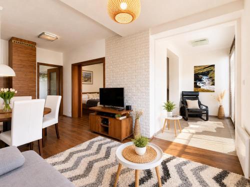 a living room with a couch and a tv at Ski & Sun Wellness Apartments in Liptovský Mikuláš