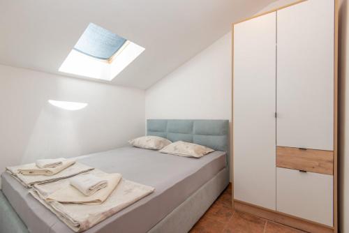 a small bedroom with a bed and a mirror at Apartment Veslo in Begovići