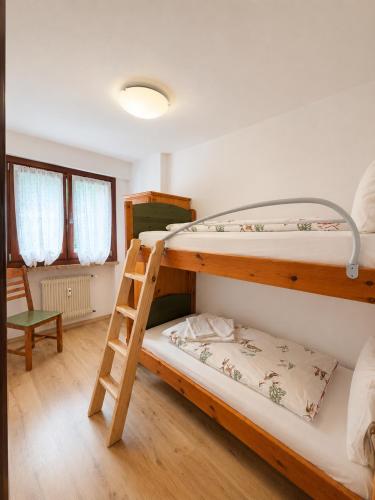 a bedroom with two bunk beds and a ladder at Appartamento Italia in Alleghe