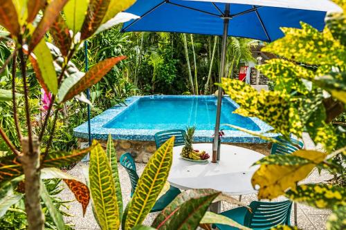 a table with an umbrella next to a swimming pool at Casa ANTAHKARANA in Puerto Vallarta