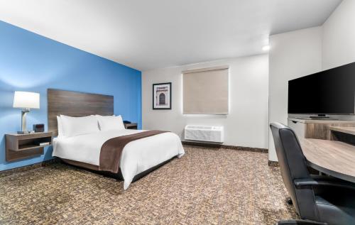 a hotel room with a bed and a flat screen tv at My Place Hotel-Jonesboro, AR in Jonesboro