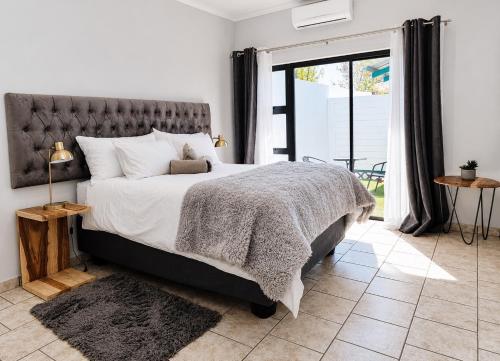 a bedroom with a bed and a large window at CAVE Properties Group in Pionierspark