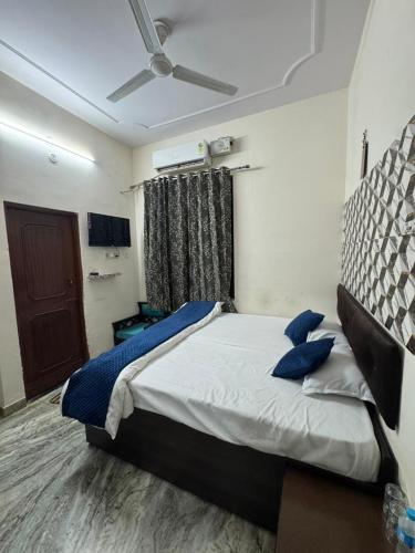 a bedroom with a bed with blue pillows on it at Basuki Hotel in Jaipur