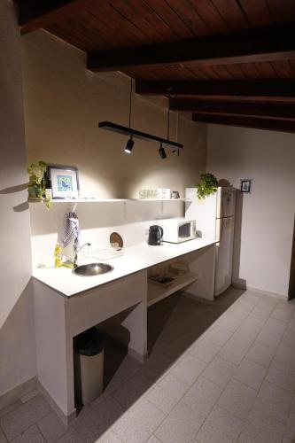 a kitchen with a sink and a refrigerator at El Retorno Hostel in Puerto Madryn