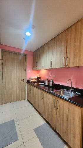 a kitchen with wooden cabinets and a sink at 1556 Shore Residences tower C - MOA in Sampong