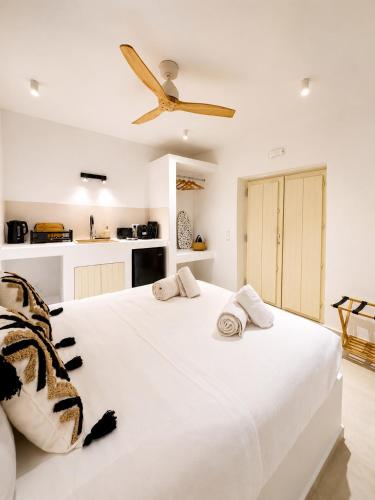 a bedroom with a large white bed with a ceiling fan at Anastasia's Luxury Suite with jacuzzi in Angairiá