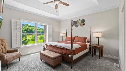 a bedroom with a bed and a chair and a window at TeeTime Green On the Fairway in Camdenton