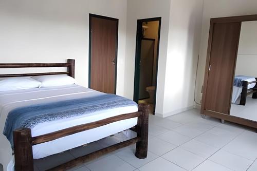 a bedroom with a bed and a mirror at Casa do Renato Charmosa em Lençóis by LVF in Lençóis