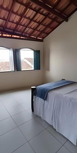 a bedroom with a bed and two windows at Casa do Renato Charmosa em Lençóis by LVF in Lençóis