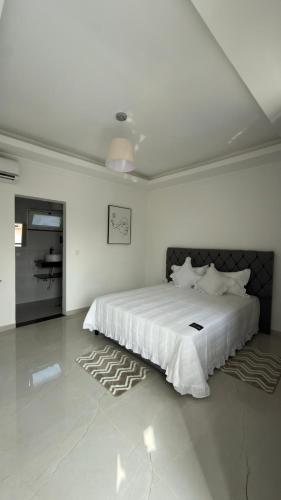 a white bedroom with a large white bed in it at Residencial Ru-B in Luanda
