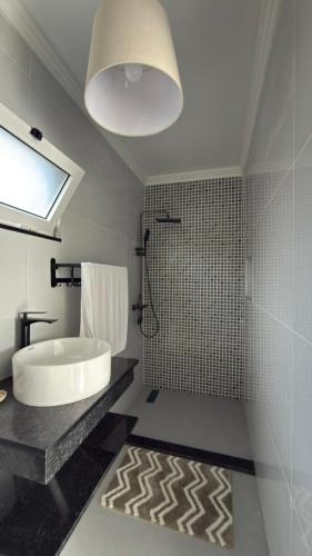 a bathroom with a tub and a sink and a shower at Residencial Ru-B in Luanda