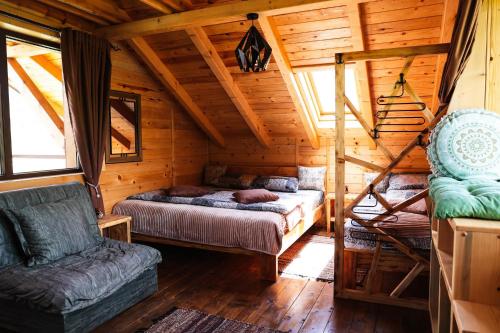 a bedroom with two beds in a wooden cabin at Kraljica Radoinja in Kokin Brod