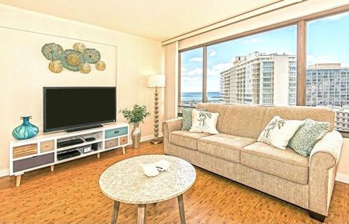 a living room with a couch and a flat screen tv at Discovery Bay 1419 in Honolulu