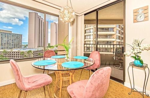 a dining room with a table and pink chairs at Discovery Bay 1419 in Honolulu