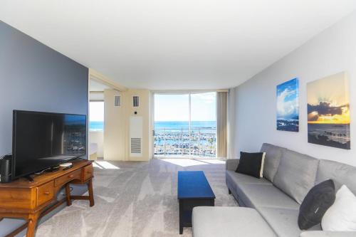 a living room with a couch and a flat screen tv at Ilikai Marina 1386 in Honolulu