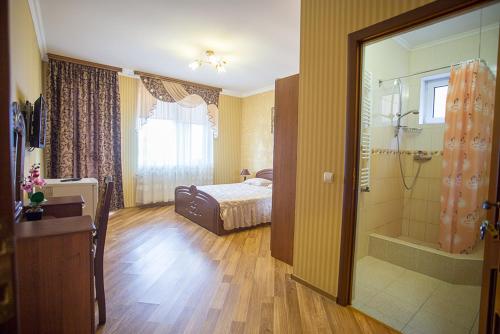ein Schlafzimmer mit einem Bett und ein Badezimmer mit einer Dusche in der Unterkunft Goldenluxe in Berehowe