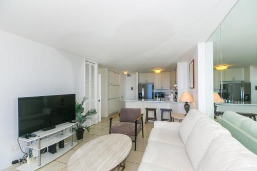 a living room with a white couch and a tv at Ilikai Marina 1688 in Honolulu