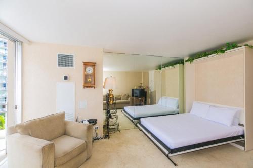 a bedroom with a bed and a couch and a chair at Ilikai Marina 985 in Honolulu