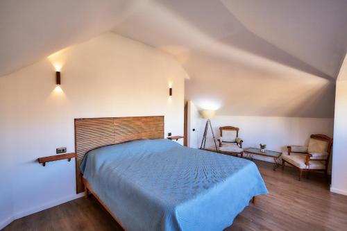 a bedroom with a blue bed and a chair at Casa Hotel Antigua Viña in Viña del Mar