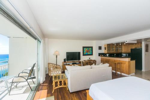 a living room with a couch and a kitchen at Ilikai Tower 1228 in Honolulu