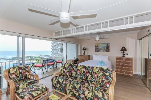 a bedroom with a bed and a balcony with the ocean at Ilikai Tower 1314 in Honolulu