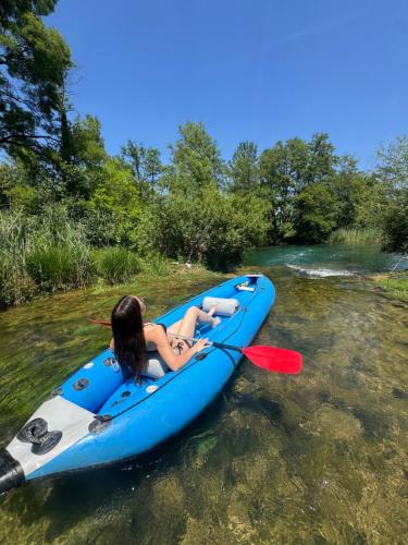 a woman in a blue kayak on a river at La casa de Nora in Duga Resa