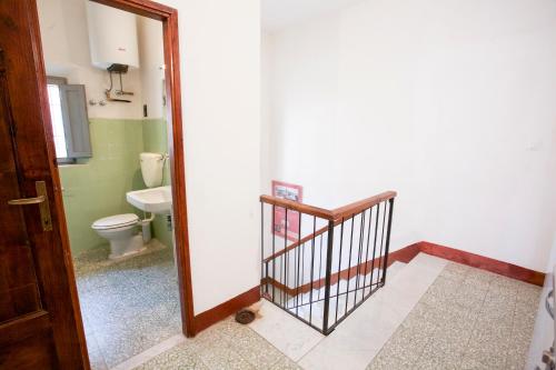 a bathroom with a toilet and a hallway with a door at Appartamento Podere San Marco in Portoferraio