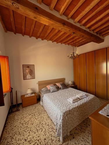 a bedroom with a bed in a room with wooden ceilings at Casa Vicolo in Peccioli