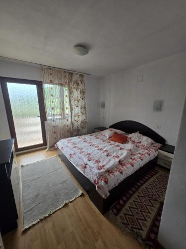 a bedroom with a bed and a window at Vila Mihnea in Moieciu de Jos